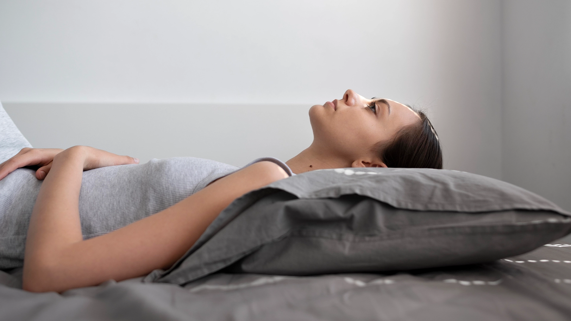 Mulher deitada respirando pelo nariz, ilustrando qualidade do sono