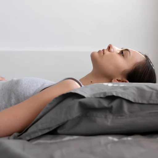 Mulher deitada respirando pelo nariz, ilustrando qualidade do sono